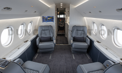 Interior refurbishment of Falcon 2000 with blue-gray club seats looking to front of the plane