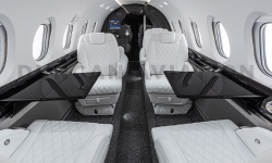 Black lacquer conference tables with white leather club seats in updated Hawker 800