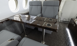 Gray leather seats with fold out dark wood table in Falcon 900