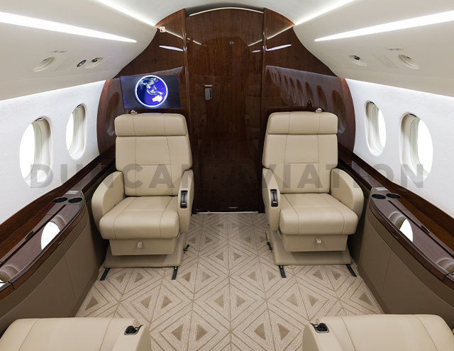 Interior of newly refurbished Falcon 2000 by Duncan Aviation with tan upholstery and dark wood accents