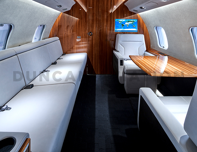 White leather divan and two seats with table in refurbished Global Express