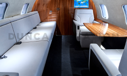White leather divan and two seats with table in refurbished Global Express