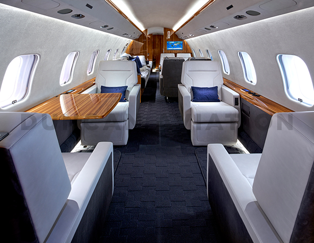 Refurbished interior by Duncan Aviation of Global Express with dark gray carpet, white leather seats and warm wood accents