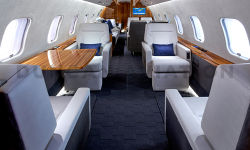 Refurbished interior by Duncan Aviation of Global Express with dark gray carpet, white leather seats and warm wood accents