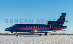 Falcon 900 painted by Duncan Aviation in rich navy with magenta and light blue stripe