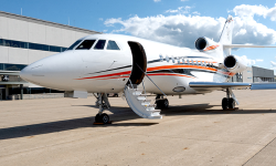 Falcon 900 with cabin door open, newly painted white with orange and navy stripes by Duncan Aviation