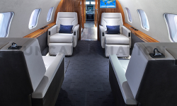 Refurbished interior of Global Express with white leather seats, dark gray carpet and warm wood tones by Duncan Aviation