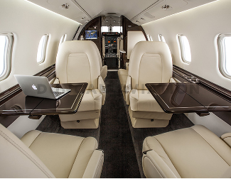 Interior of updated Learjet 60 with cream upholstery and dark wood