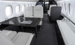 Interior refurbishment of Falcon 2000 with white leather club seats, conference table and credenza