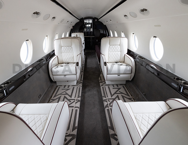 Newly refurbished interior of Gulfstream 200 with white leather and dark piping