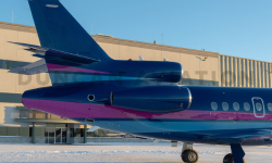 Tail of newly painted Falcon 900 with matching magenta and navy stripe against dark blue background