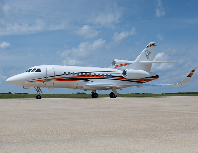 Exterior of Falcon 900 in white with blue and orange strip painted by Duncan Aviation